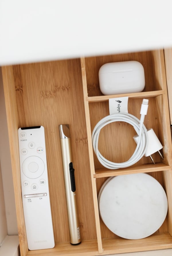 A drawer opened with nightstand organization of remotes, lotions and more