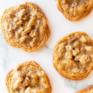 Pecan pie cookies laid out on a white surface.